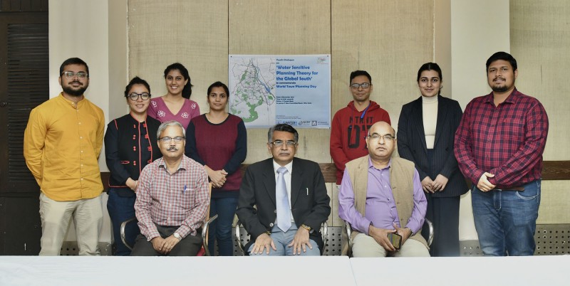 SPA colleagues sit and stand together for a photo with a poster titled 'Water Sensitive Planning Theory for the Global South' visible behind
